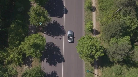 Drone Descending Close On Convertible Tree-Lined Road Stock Footage 338046195