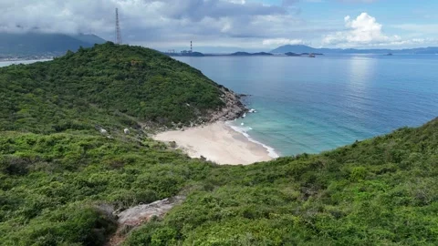 Drone descending from forested hill to pristine tropical beach 스톡 동영상 336974357