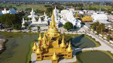 Drone Descending Front View of Golden Ganesha Temple with White Temple Chiang Ra Stock Footage 332573246
