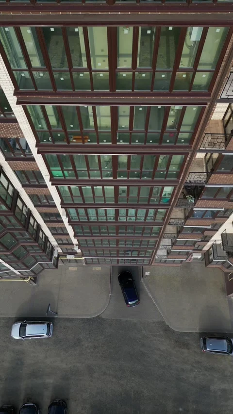 Drone descending into a modern apartment complex courtyard Video stock 335405588