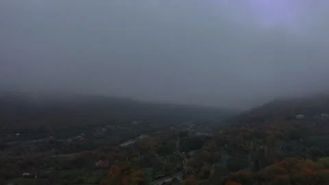 Drone Descending Through Clouds Towards Autumn Village 動画素材 318891362