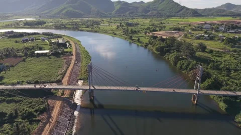 Drone descending toward bridge over river in Vietnam Stock Footage 339753636
