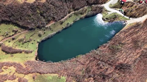 Drone Descending Toward Crystal Blue Lake From High Altitude in 4K Stock Footage 339069708