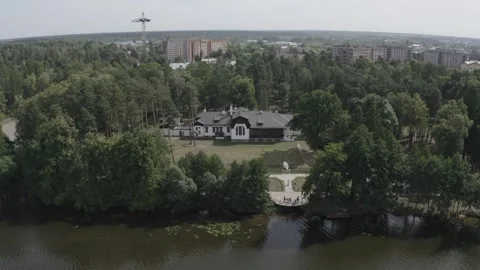 Drone descending toward forest house by river 動画素材 333484699