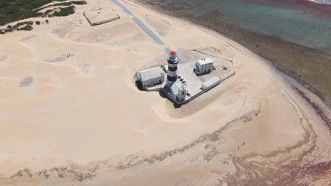 Drone Descending Towards Lighthouse with Beach, Shallow Sea, Small Waves, Reflec Stock Footage 306303596