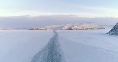 Drone Descends Above Trail Left by a Boat on the Ice of a Frozen Lake. Winter Video stock 139615056