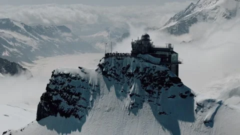 Drone descends below sheer observatory cliff of Jungfraujoch Switzerland Stock Footage 279125368