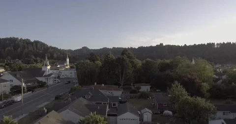 Drone descends diagonally over the small road in Suburban Town | Aerial Shot Stock Footage