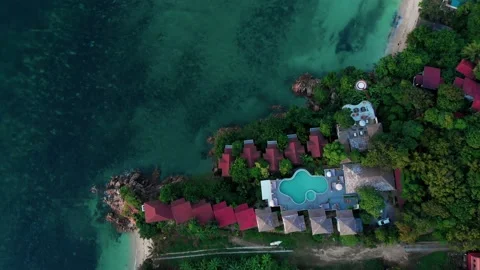 Drone descends over beach with rooftops summer vacation resort. Break into Stock Footage 237218000