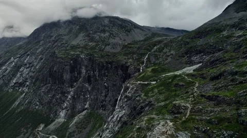 Drone Descends Over the Cliffs and Trollfossen Waterfall on Trollstigen, Norway Stock Footage 330107622