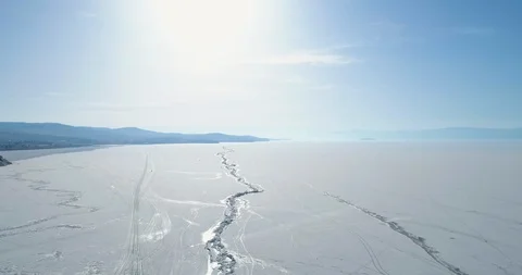 Drone descends over ice crack of a frozen lake Baikal. Winter landscape Aerial Stock Footage 106620696