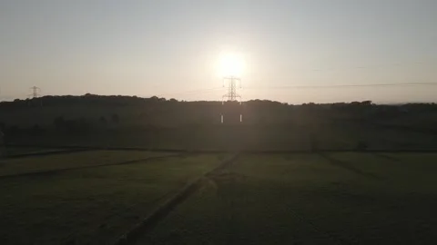 Drone Descent with Sun Behind Electricity Pylon Stock Footage 339075537