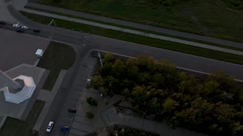 Drone Descent from Sunset Cityscape to Parking Lot by Flagpole Stock Footage 310303510