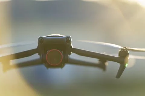 Drone with digital camera and fast rotating propellers flying taking video and Stock Photos