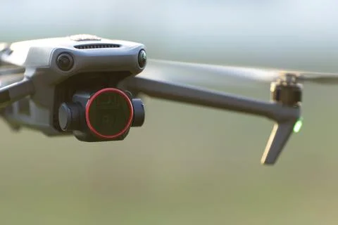 Drone with digital camera and fast rotating propellers flying taking video Stock Photos