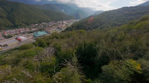 Drone dive above green forest to mountain resort Stock Footage 311078346