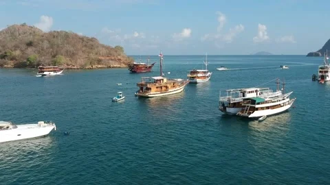 Drone, dive boats floating on calm blue water, islands in background, Indone Stock Footage 131434489
