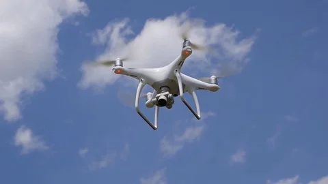 Drone DJI Phantom 4 in flight. Quadrocopter against the blue sky with white clou Stock Footage 76199918