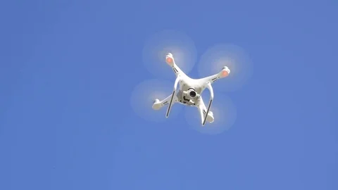 Drone DJI Phantom 4 in flight. Quadrocopter against the blue sky with white Stock Footage 85148215