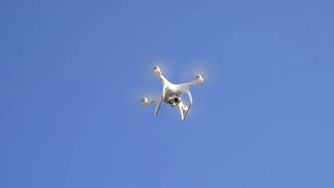 Drone DJI Phantom 4 in flight. Quadrocopter against the blue sky with white Stock Footage 85148349
