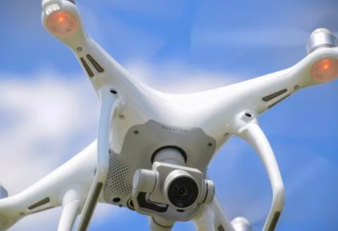 Drone DJI Phantom 4 in flight. Quadrocopter against the blue sky Stock Photos