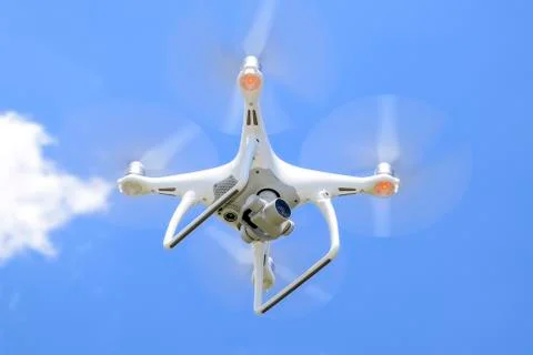 Drone DJI Phantom 4 in flight. Quadrocopter against the blue sky