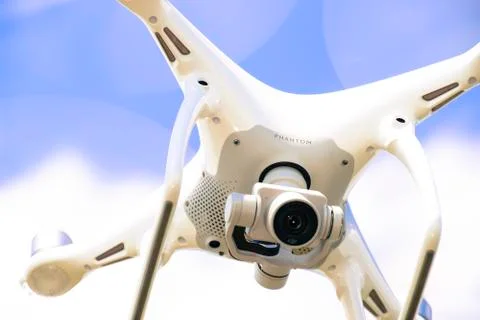 Drone DJI Phantom 4 in flight. Quadrocopter against the blue sky Stock Photos