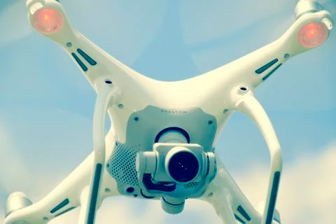 Drone DJI Phantom 4 in flight. Quadrocopter against the blue sky Stock Photos