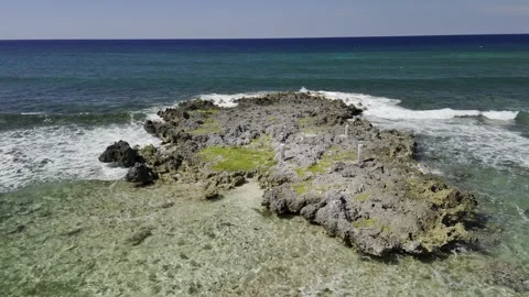 Drone does 360 around rock formation above water on top of reef Vídeo Stock 307107827