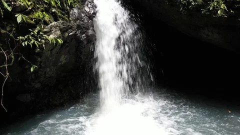 Drone dolly out shot of small waterfall and pond in dense tropical forest, 4k Video stock 122554355