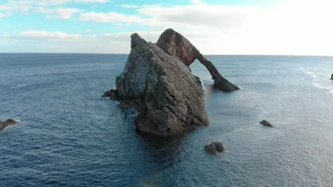 Drone Dolly Up Shot of Bow Fiddle Rock Sea Arch on Calm Blue Sea Scotland Stock Footage 336754291