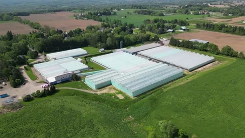 Drone - Down to Up Quick Fly Away of Greenhouses with Roads, Farms &amp; Towns Stock Footage 314227796