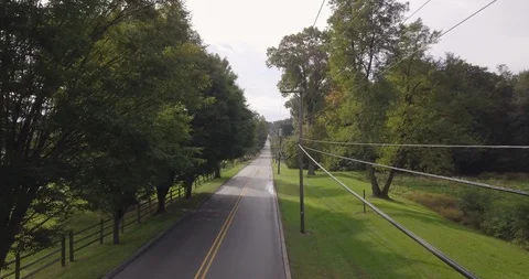Drone down road flying next to telephone wires Stock Footage 97093828