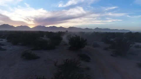 Drone dramatic backlit desert mountain at sunrise tracking left to right Stock Footage 104883970