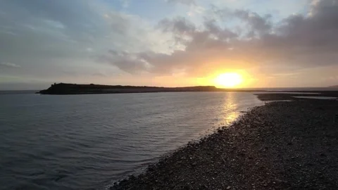 Drone: Dramatic 'fireball' sunset seen over sea &amp; island Stock Footage 322044815