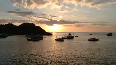 Drone, dramatic orange sky, boat and island silhouettes over ocean, Indonesi Stock Footage 131434582