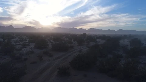 Drone dramatic rise over fog, desert and back lit mountains sunset magic hour Stock Footage 104883968