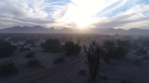Drone dramtic push in over fog, desert and back lit mountains sunset magic hour Stock Footage 104883965