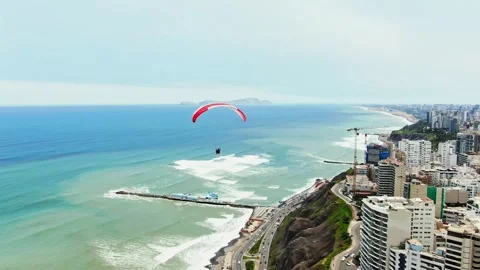 Drone drifts slowly forward with the camera tilting up and down as a paraglider Vídeo Stock 347667164