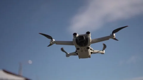 A drone, a drone with a camera in flight, hovering in the air against the sky. Stock Footage 293094665