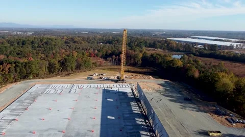 A drone elevator shot of a heavy duty crane lifting concrete panels into Video stock 221763830