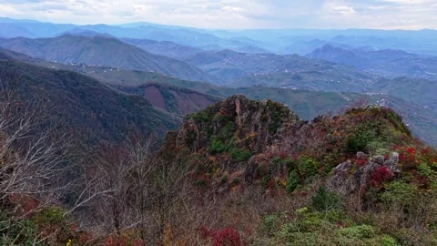 Drone Emerging From Bushes Toward Rocky Cliffs in Stormy Weather 4K Stock Footage 339008049