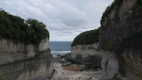 Drone Exit from Rock Canyon Toward Ocean and Melasti Beach in Bali Stockbeeldmateriaal 322892955