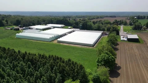 Drone - Far Away Left to Right of Greenhouses, Escarpment, Farmland, etc. Stock Footage 314227944