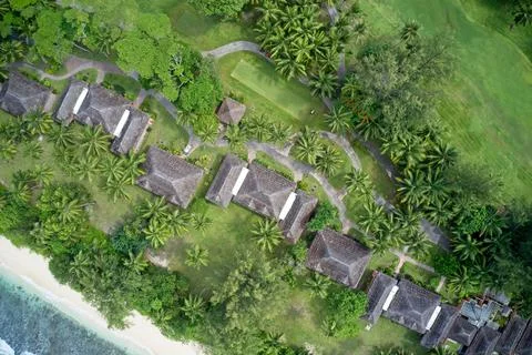 Drone field of view of chalets hidden among forest and beach in Seychelles Foto stock