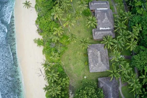 Drone field of view of chalets hidden among forest and waves in Seychelles Stock Photos
