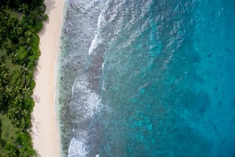 Drone field of view of empty coastline and waves meeting beach Seychelles Stock Photos