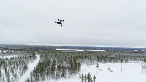 Drone filming another drone over snow filled winter forest in Finland Stock Footage 275260015