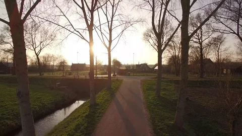 Drone filming backwards between beautiful trees and farms Stock Footage 75351080