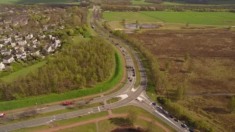 Drone filming busy intersection with traffic lights and beautiful nature Stock Footage 75349169